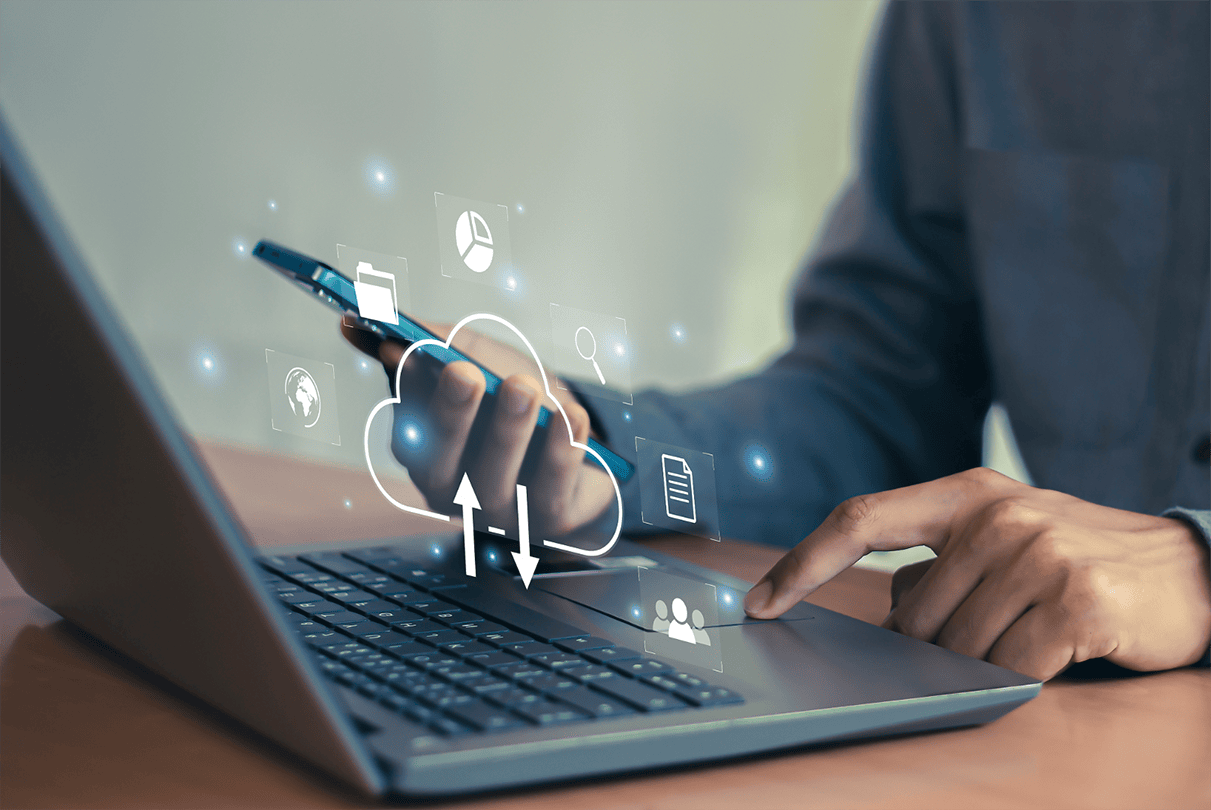 Person nutzt Smartphone und Laptop für Cloud- und IT-Sicherheitslösungen.